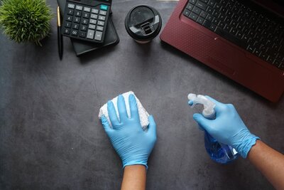 Commercial cleaning image - a cleaner cleaning a desk.